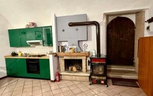 a kitchen with green cabinets and a fireplace at Casa Paulina in Scanno