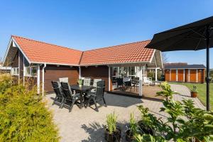a patio with a table and chairs and an umbrella at SJ285-Bjert-Kystvej-64-A in Åbjerg