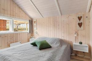 a bedroom with a bed with a green pillow on it at SJ285-Bjert-Kystvej-64-A in Åbjerg