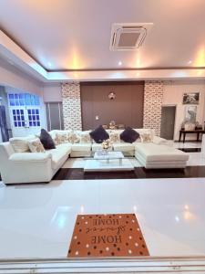 a living room with white couches and a rug at Swansea Villa 3 BR in Ban Huai Yai