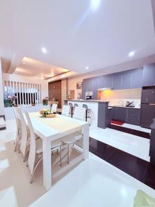 a kitchen with a white table and chairs at Swansea Villa 3 BR in Ban Huai Yai