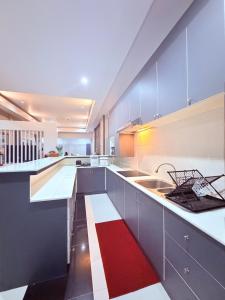 a large kitchen with white cabinets and a red rug at Swansea Villa 3 BR in Ban Huai Yai +12 photos