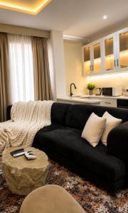 a living room with a black couch and a kitchen at D'Empire in Lekki