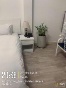 a bedroom with a bed and a table with a plant at Financeer Hotel in Ho Chi Minh City