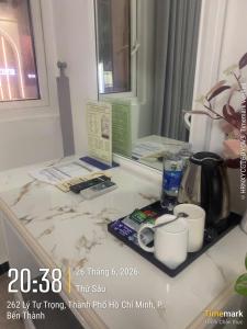 a marble counter top with a coffee maker and coffee cups at Financeer Hotel in Ho Chi Minh City