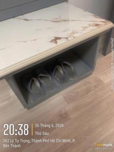 a box with three pairs of shoes under a table at Financeer Hotel in Ho Chi Minh City +1 photo