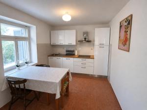 a kitchen with a table and a white refrigerator at Apartments Tomas in Ugljan