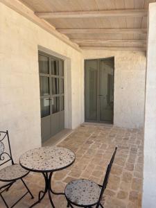 a patio with two tables and chairs and a door at Trullo botanico in Ceglie Messapica