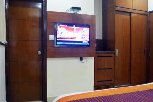 a room with a flat screen tv and wooden cabinets at Trinity Corporate Udyog Vihar in Gurgaon