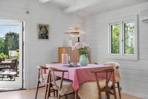 a dining room with a table with a vase of flowers at SJ291-Hejls-Brombaervaenget-36 in Hejls +12 photos