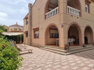 a large house with a patio and a building at MD Villa con piscina en Mareny Beach in Mareny Blau