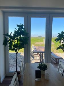 a dining room with a table with a plant on it at HaRE Ferienwohnungen een in Langeneß