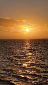 a sunset over the ocean with the sun setting at HaRE Ferienwohnungen een in Langeneß