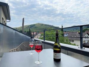 a bottle of wine and two glasses on a table at Apartment Bienenfresser in Vogtsburg