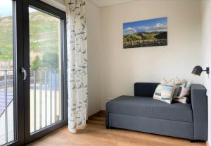 a blue couch in a room with a sliding glass door at Apartment Bienenfresser in Vogtsburg +26 photos