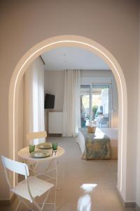 an archway in a hotel room with a bed and a table at Perea Fiore Suites in Perea