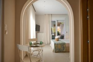 an archway leading to a bedroom with a bed and a table at Perea Fiore Suites in Perea