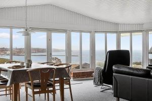 a living room with a table and chairs and the ocean at SJ290-Hejls-Ae-Skovbryn-2 in Hejls +26 photos