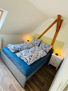 a bedroom with a blue bed with pillows on it at HaRE Ferienwohnung DREE in Langeneß