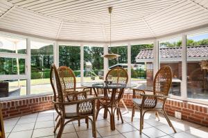 a screened in porch with a table and chairs at SJ290-Hejls-Ae-Skovbryn-2 in Hejls