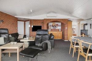 a living room with leather furniture and a brick wall at SJ290-Hejls-Ae-Skovbryn-2 in Hejls