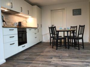 a kitchen with a table and chairs in a room at HaRE Ferienwohnung twee in Langeneß