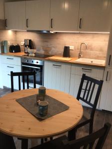 a kitchen with a wooden table with chairs and a sink at HaRE Ferienwohnung twee in Langeneß