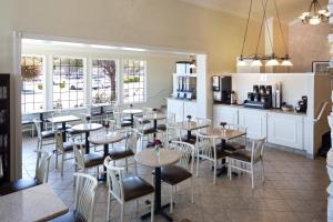 um restaurante com mesas e cadeiras e uma cozinha em The Marina Inn on San Francisco Bay em San Leandro