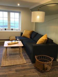 a living room with a couch and a table at HaRE Ferienwohnung twee in Langeneß +24 photos