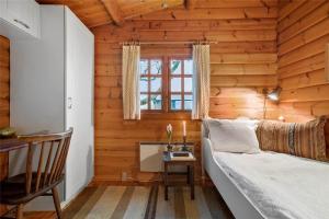 a bedroom in a log cabin with a bed and a desk at LN1500-Hirtshals-Kranken-11 in Hirtshals