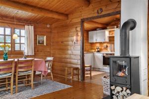 a kitchen and dining room with a fireplace in a cabin at LN1500-Hirtshals-Kranken-11 in Hirtshals +20 photos