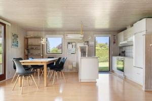 a kitchen and dining room with a table and chairs at SJ299-Hejlsminde-Poppelvaenget-4 in Hejlsminde