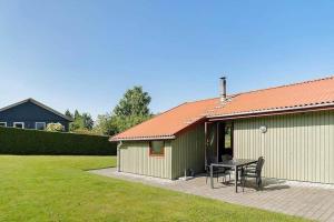 a building with a table and chairs in a yard at SJ299-Hejlsminde-Poppelvaenget-4 in Hejlsminde