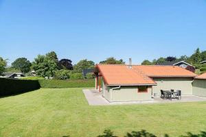 a small house with a grassy yard next to a building at SJ299-Hejlsminde-Poppelvaenget-4 in Hejlsminde +19 photos