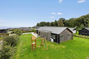 a tiny house with a playground in a yard at SJ302-Haderslev-Blokhusskoven-63 in Haderslev
