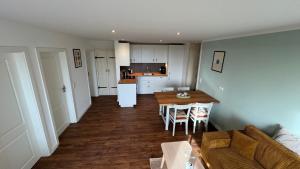 a kitchen and living room with a table and a couch at HaRE Ferienwohnungen Käptn Magda in Langeneß