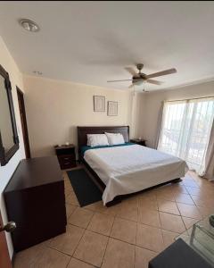 a bedroom with a bed and a ceiling fan at Tropical Stay in Coco in Coco