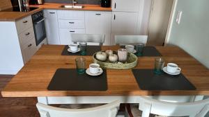 a kitchen with a wooden table with chairs and a dining room at HaRE Ferienwohnungen Käptn Magda in Langeneß