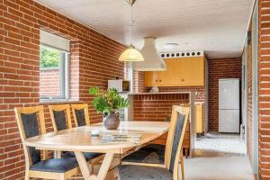 a kitchen with a table and chairs and a brick wall at SJ300-Haderslev-Vikaerparken-87 in Haderslev