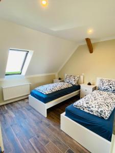 a bedroom with two beds and a window at HaRE Ferienwohnungen VEER in Langeneß