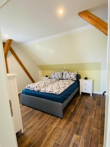 a bedroom with a bed and a wooden floor at HaRE Ferienwohnungen VEER in Langeneß