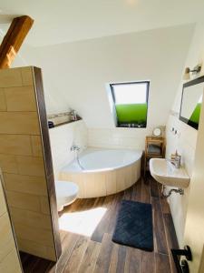 a bathroom with a tub and a sink at HaRE Ferienwohnungen VEER in Langeneß