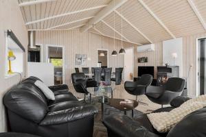 a living room with black leather couches and chairs at SJ301-Hejls-Teglgardsvej-3 in Hejls