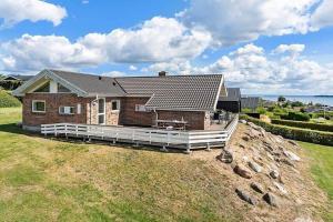 a brick house with a white fence on a yard at SJ301-Hejls-Teglgardsvej-3 in Hejls