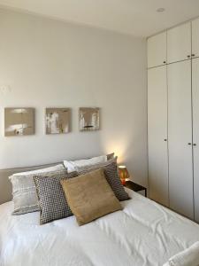 a bedroom with a white bed with pillows at JC Apartments in Amadora