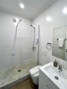 a bathroom with a shower and a toilet and a sink at JC Apartments in Amadora