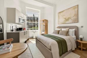 a small bedroom with a bed and a kitchen at GuestReady - The Crescent in London