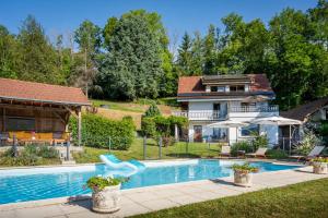 a house with a swimming pool in front of a house at La Colline aux Rêves - Chambres d'hôtes in Saint-Franc