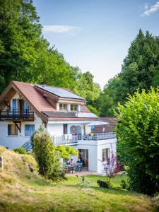 a large white house with a balcony and trees at La Colline aux Rêves - Chambres d'hôtes in Saint-Franc
