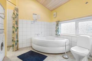 a bathroom with a white tub and a toilet at LN1971-Lonstrup-Kirkedalsvej-7 in Lønstrup +13 photos